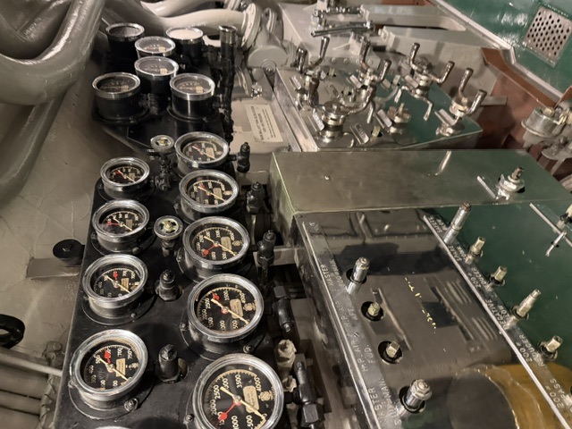 A high-pressure air manifold station aboard USS Drum, showing rows of pressure gauges above a bank of valves with stenciled labels such as 'H.P. AIR,' 'MASTER,' 'FWD,' 'AFT,' and 'BYPASS.'