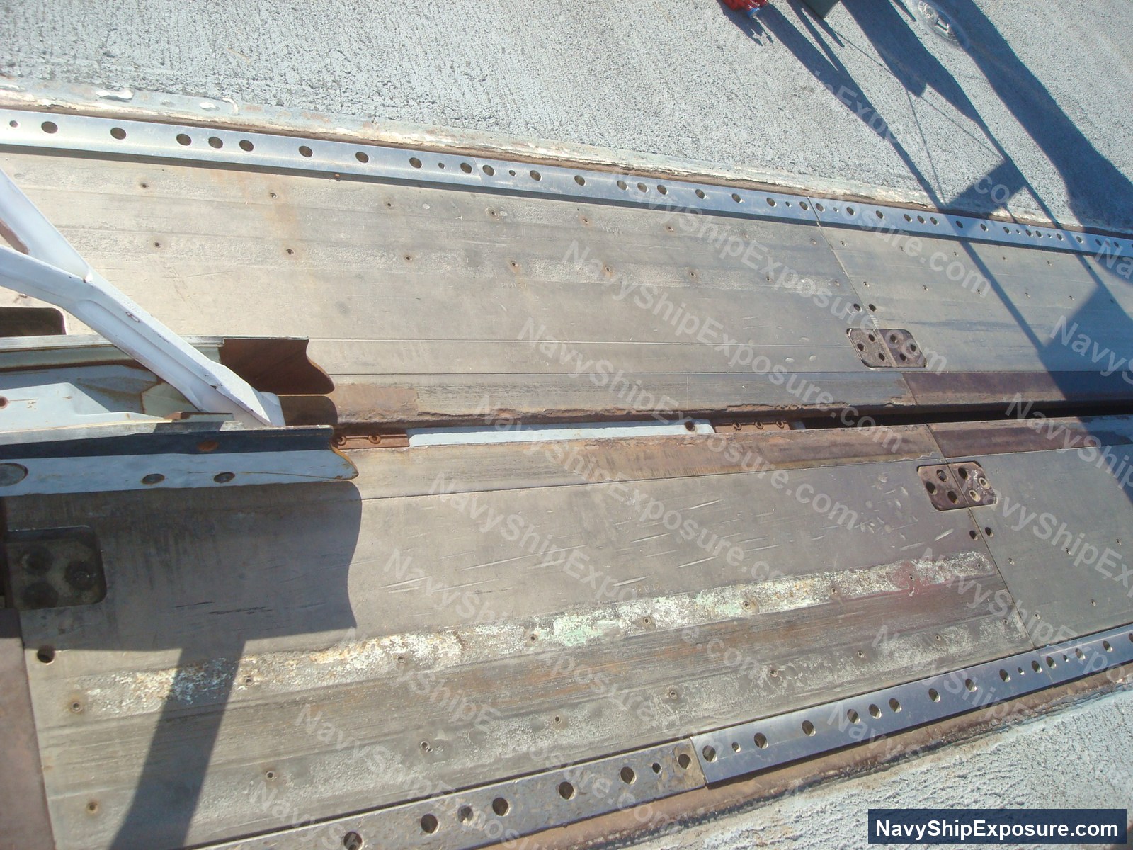 USS Midway — Close-up photograph of structural steel beams and angle iron with rivet holes and metal straps, typical of aircraft carrier interior construction and machinery space framework from the WWII-era Essex-class carrier USS Midway.