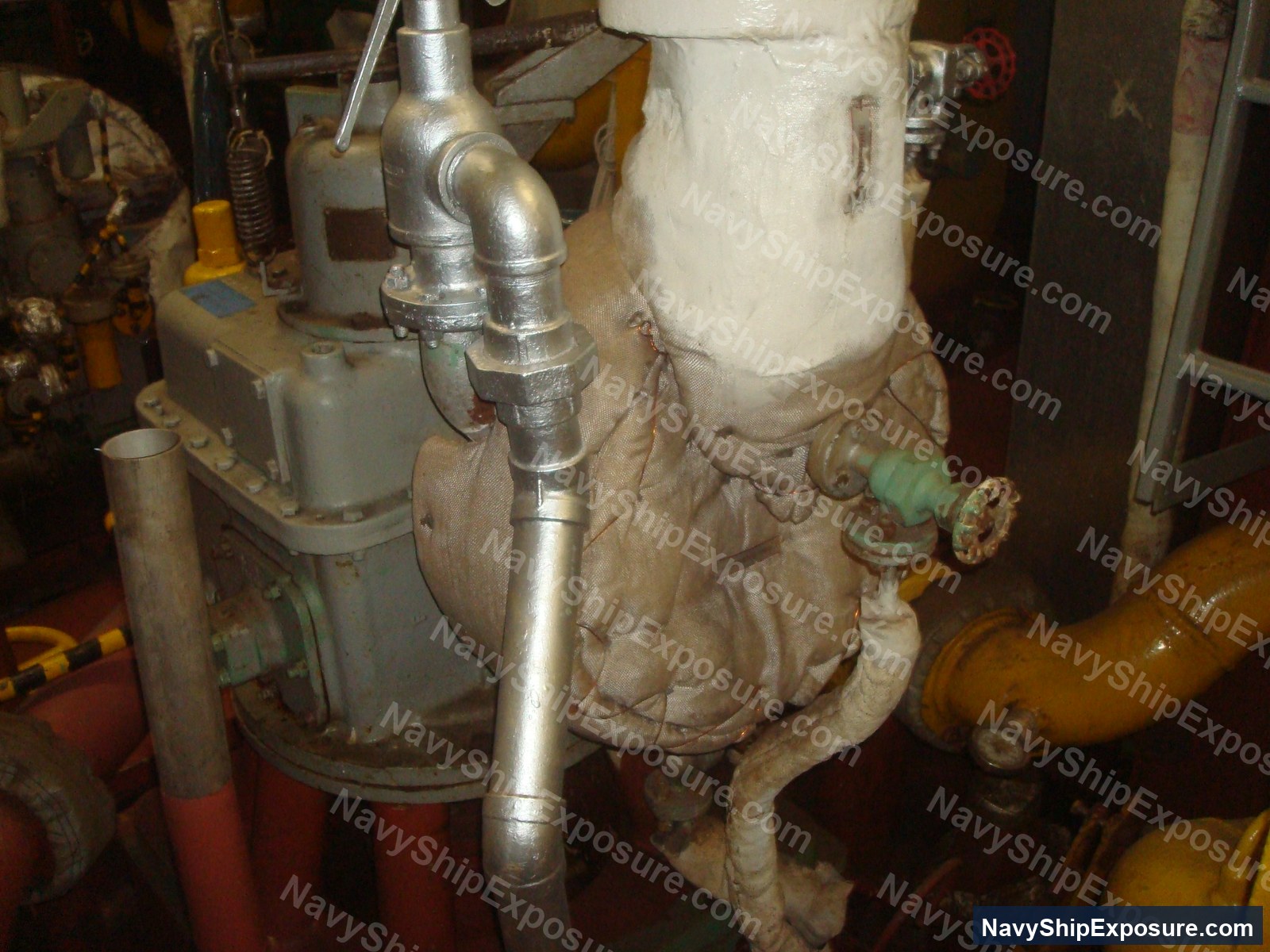 USS Midway — Engine room or machinery space equipment showing insulated piping, valves, and thermal insulation wrapping typical of steam plant systems aboard USS Midway.