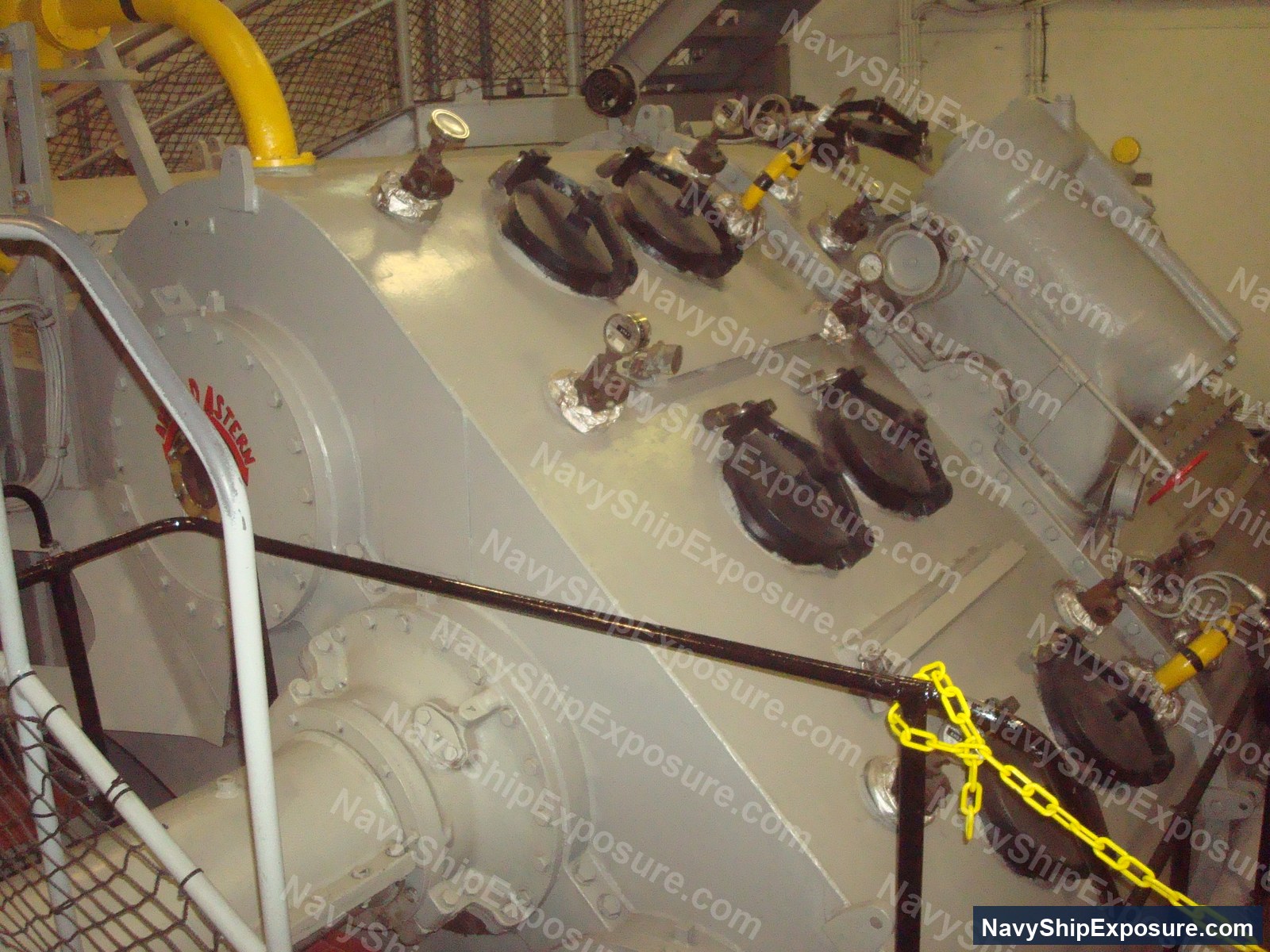 USS Midway — Engine room or machinery space aboard USS Midway showing large industrial pumps or compressors with associated piping, valves, and engineering equipment typical of a 1940s-era aircraft carrier's propulsion or support systems.