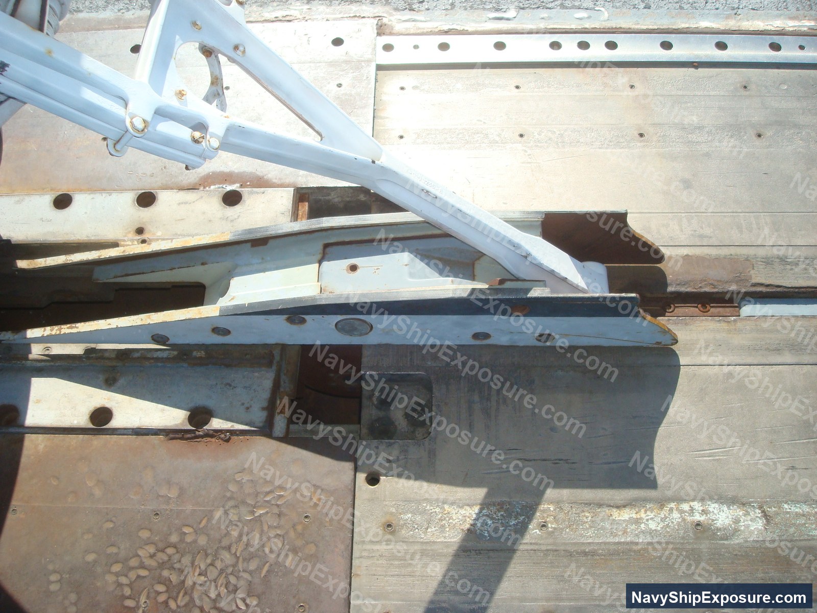 USS Midway — Close-up photograph of ship machinery components including metal structural elements, piping, and mechanical fixtures from USS Midway's engine or machinery spaces.