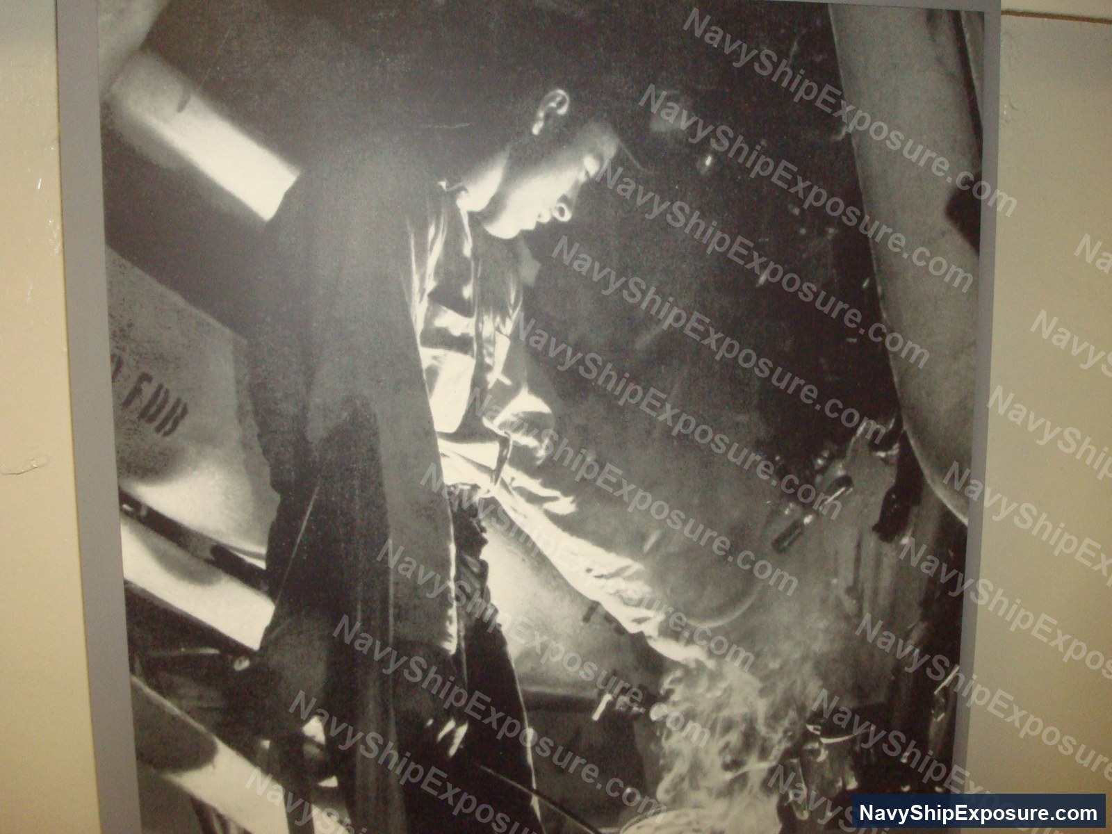 USS Midway — Black and white photograph of a USS Midway boiler room showing personnel working near large cylindrical boiler equipment and steam piping systems.