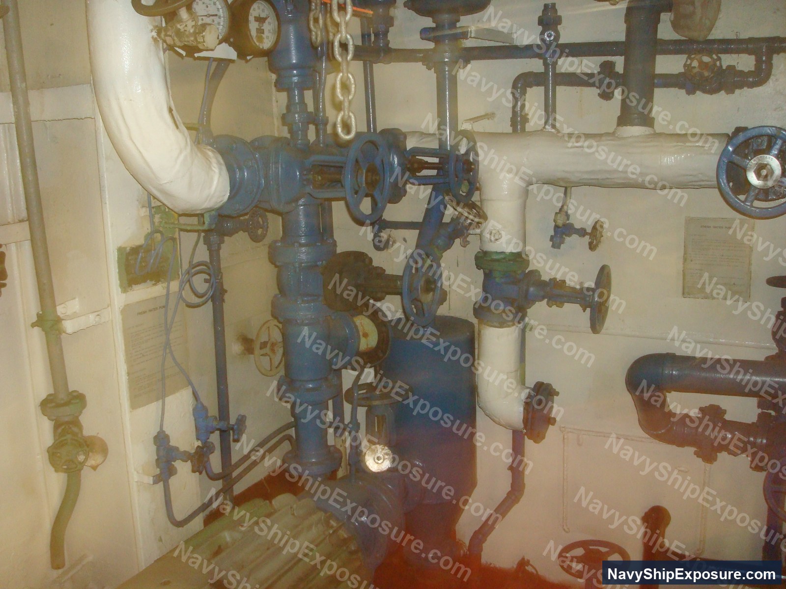 USS Midway — Interior view of USS Midway engine room or machinery space showing complex piping systems, valves with hand wheels, and steam distribution equipment typical of a World War II-era aircraft carrier's propulsion system.