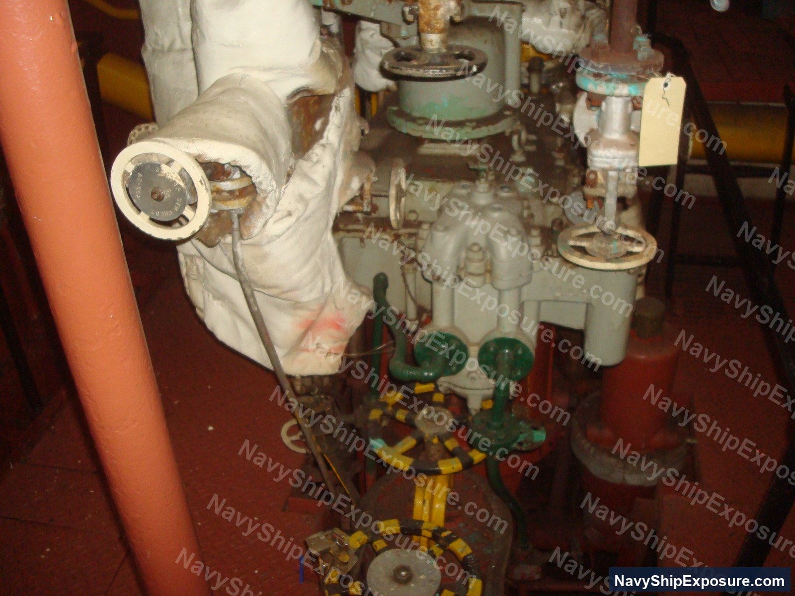 USS Midway — Engine room or machinery space from USS Midway showing insulated piping, valves, and industrial equipment typical of 1940s-1950s naval steam propulsion systems.