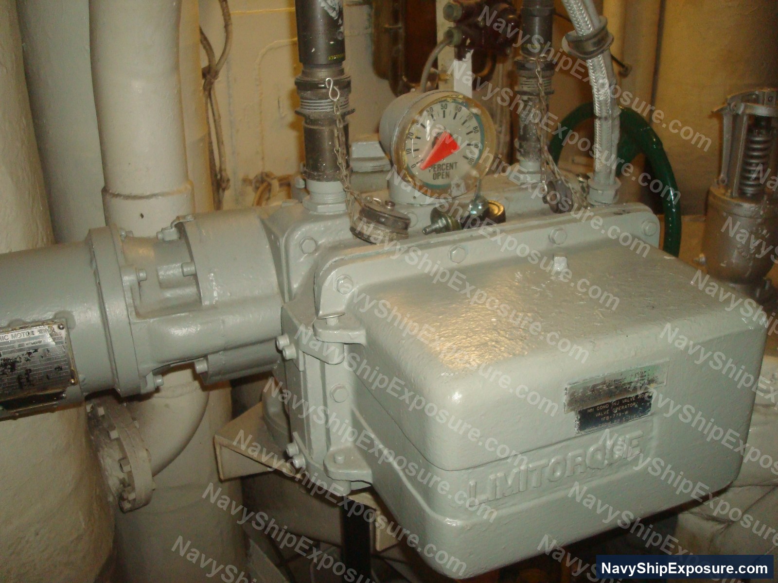 USS Midway — Engine room or machinery space equipment showing a Limitorgue pressure gauge, pump, piping, and various industrial valves typical of USS Midway's propulsion system.
