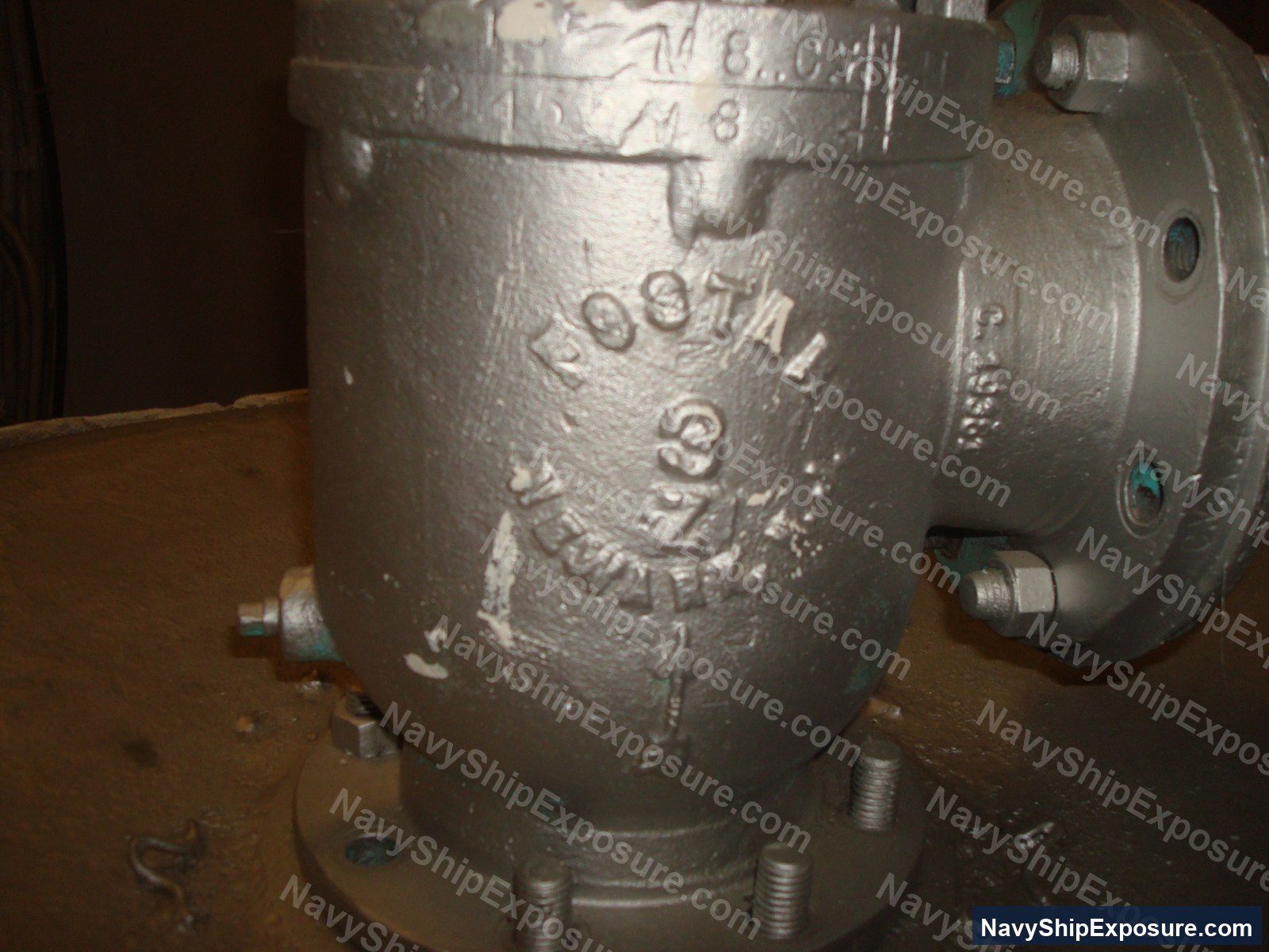 USS Midway — Close-up photograph of an industrial pump or compressor unit with cast metal housing and visible serial number marking, typical of machinery found in naval vessel engine rooms.