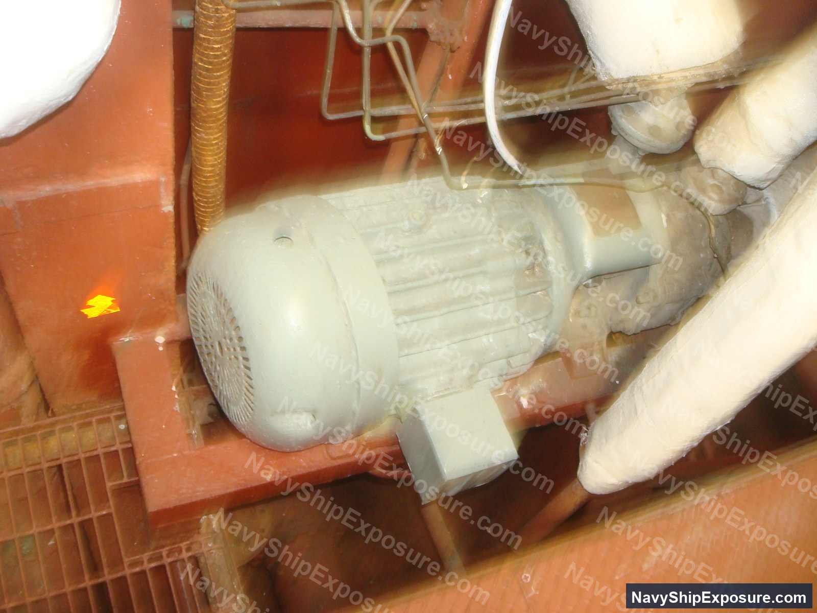 USS Midway — Electric motor mounted on red structural framing in an engine room or machinery space of USS Midway, showing typical 1940s-era naval equipment installation with visible piping and wiring.